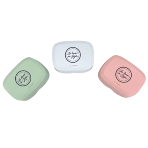 Trois boîtes à savon rectangulaires de Les Savons de Joya dans des teintes pastel : vert, blanc et rose.