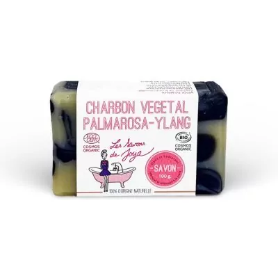 Savon CHARBON VÉGÉTAL PALMAROSA-YLANG de la marque Les Savons de Joya, arborant des labels COSMOS ORGANIC et BIO. Ce savon de 100g est marbré de noir, indiquant l'utilisation de charbon actif, et est 100% d'origine naturelle.